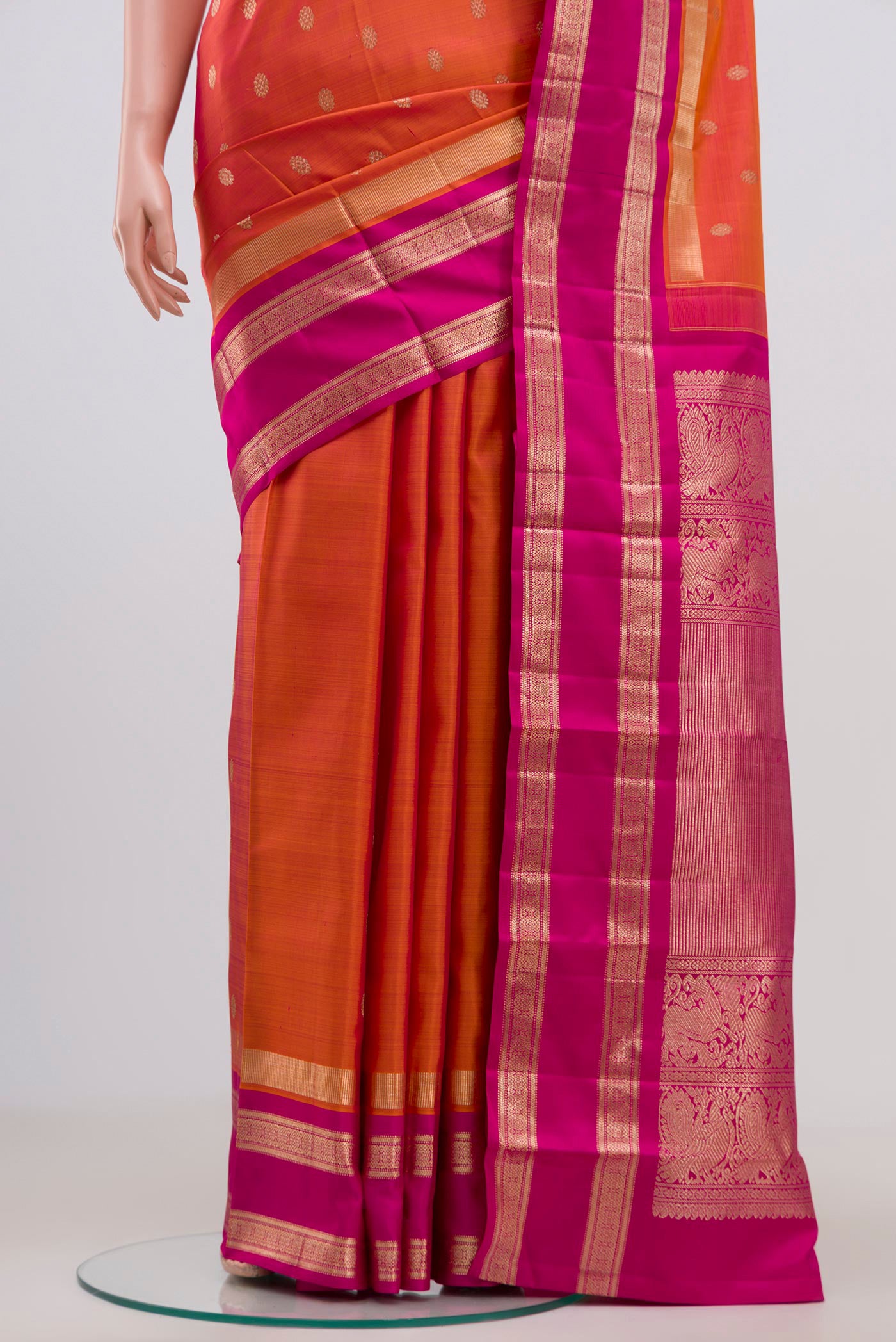 Pleats and pallu of Orange Kanjivaram Saree with Zari Butta on the body and Zari Border. 