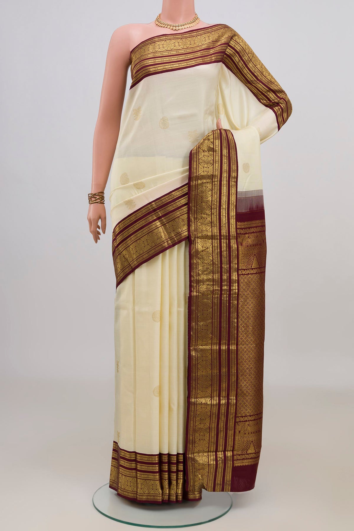 Pure Silk Cream Kanchipuram Saree with Zari Butta on the body and Zari Border.  displayed on a mannequin