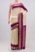 Cream Kanchipuram Silk Saree with Zari Brocade on the body and Zari Border.  displayed on a mannequin