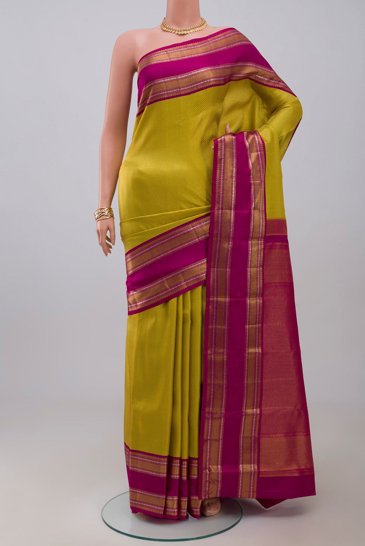 Parrot Green Kanchipuram Saree with Zari Brocade on the body and Zari Border.  displayed on a mannequin
