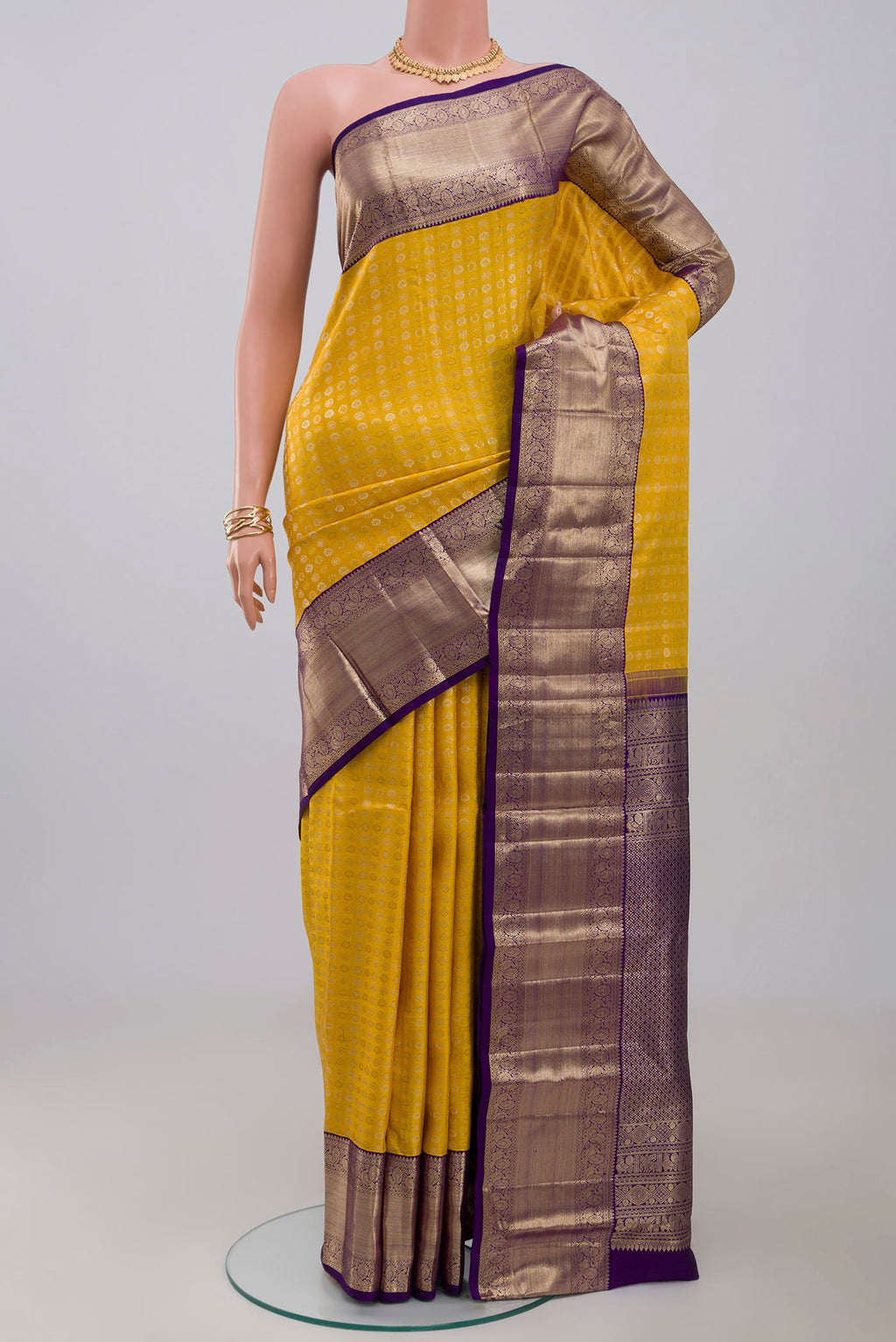 Yellow Kanchipuram Silk Saree with Zari Butta on the body and Zari Border.  displayed on a mannequin