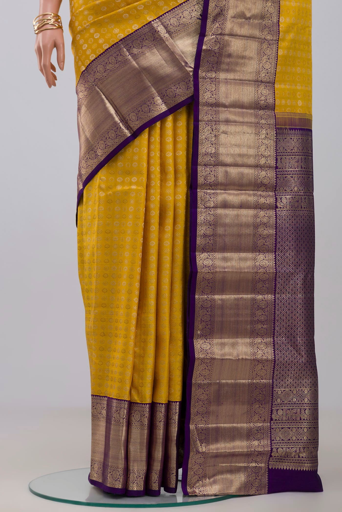 Pleats and pallu of Yellow Kanchipuram Silk Saree with Zari Butta on the body and Zari Border. 
