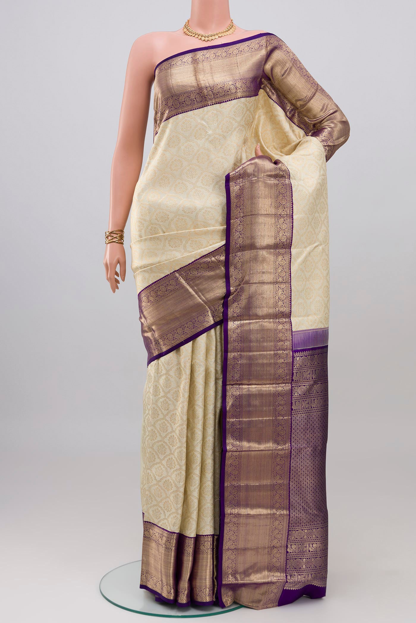 Cream Kanchipuram Silk Saree with Zari Brocade on the body and Zari Border.  displayed on a mannequin