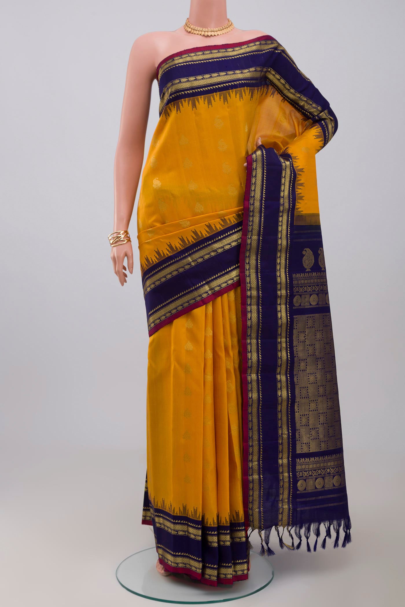 Yellow Gadwal Silk Saree with Zari Butta on the body and Zari Border.  displayed on a mannequin