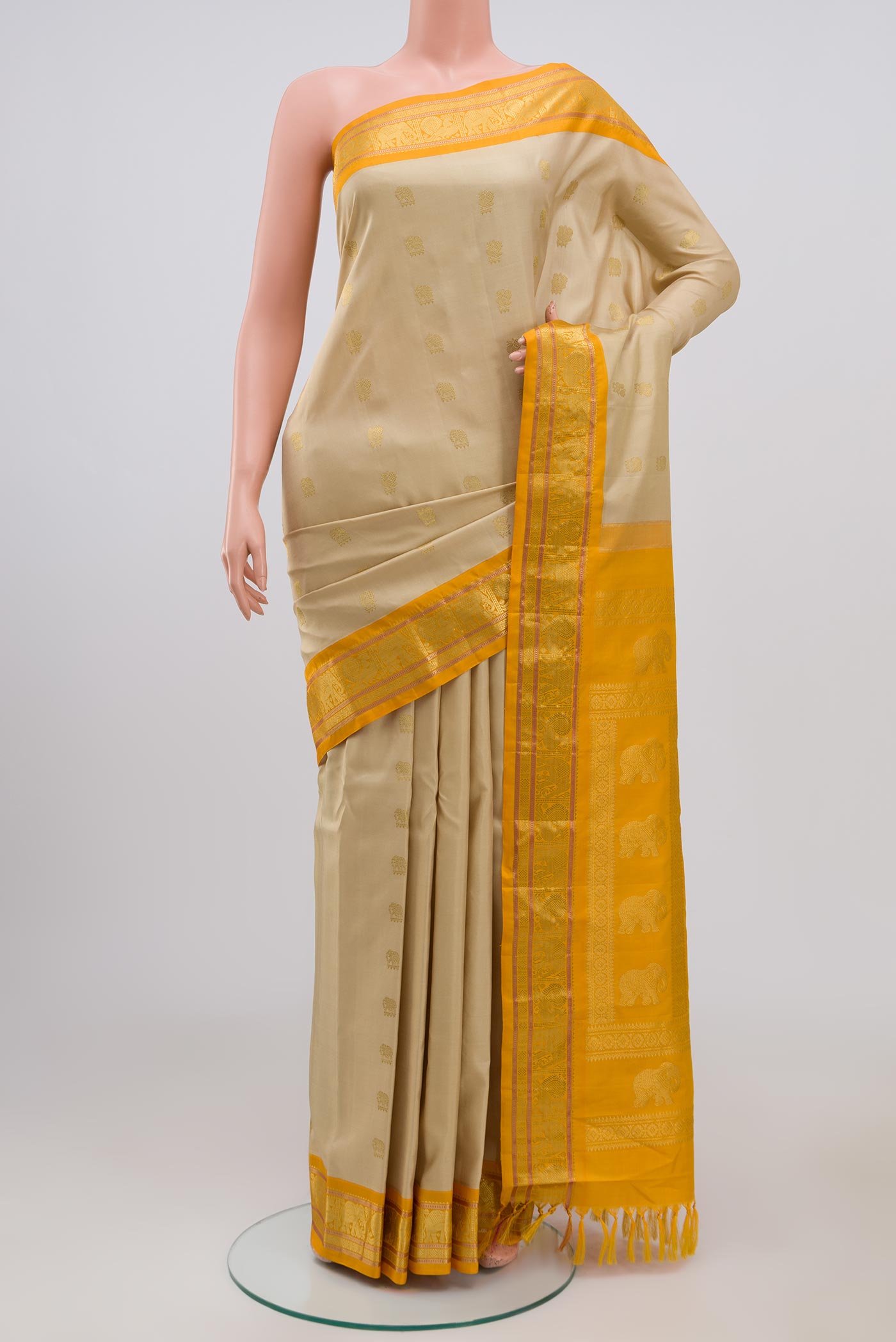 Cream Gadwal Silk Saree with Zari Butta on the body and Zari Border.  displayed on a mannequin