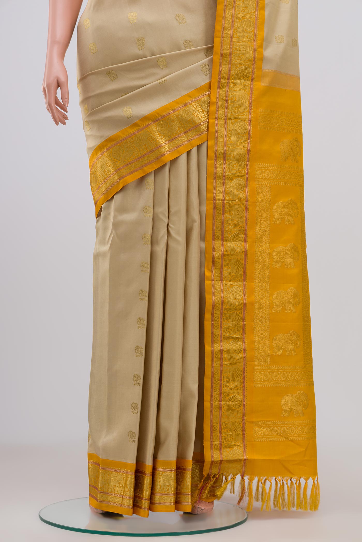 Pleats and pallu of Cream Gadwal Silk Saree with Zari Butta on the body and Zari Border. 