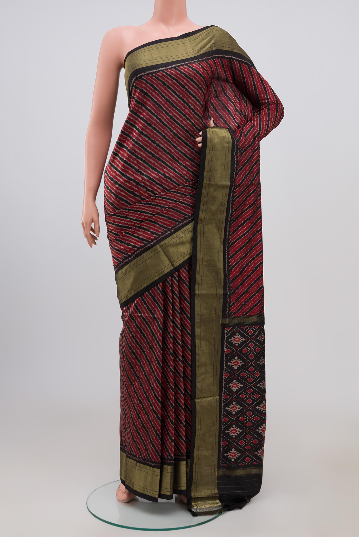 Maroon Pochampally Silk Saree with Ikat design on the body and Zari Border.  displayed on a mannequin