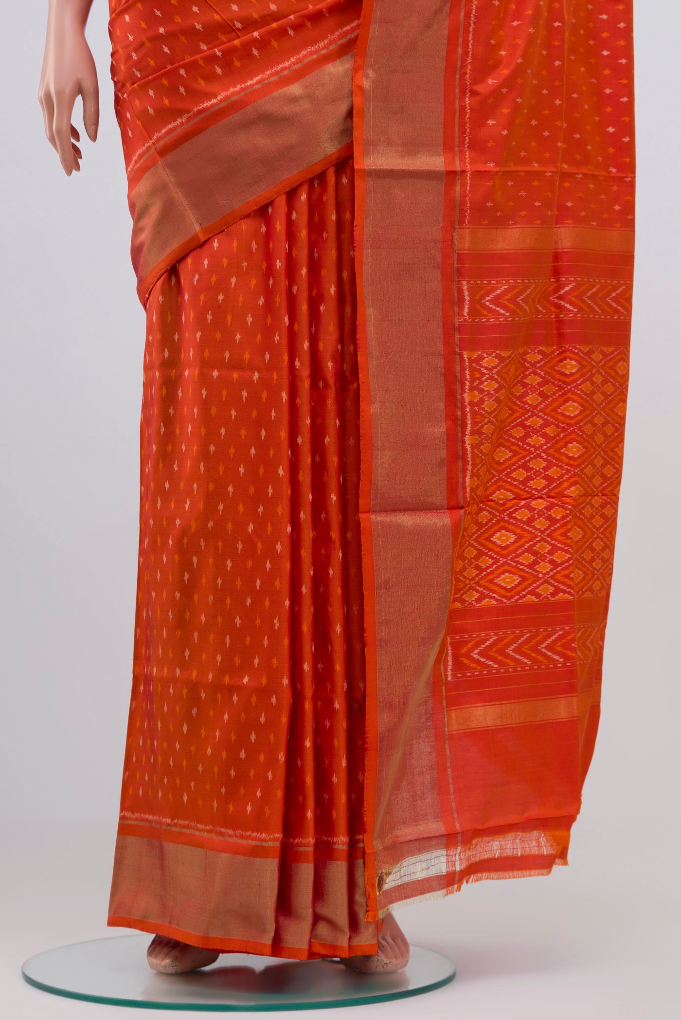 Pleats and pallu of Orange Pochampally Silk Saree with Ikat design on the body and Zari Border. 
