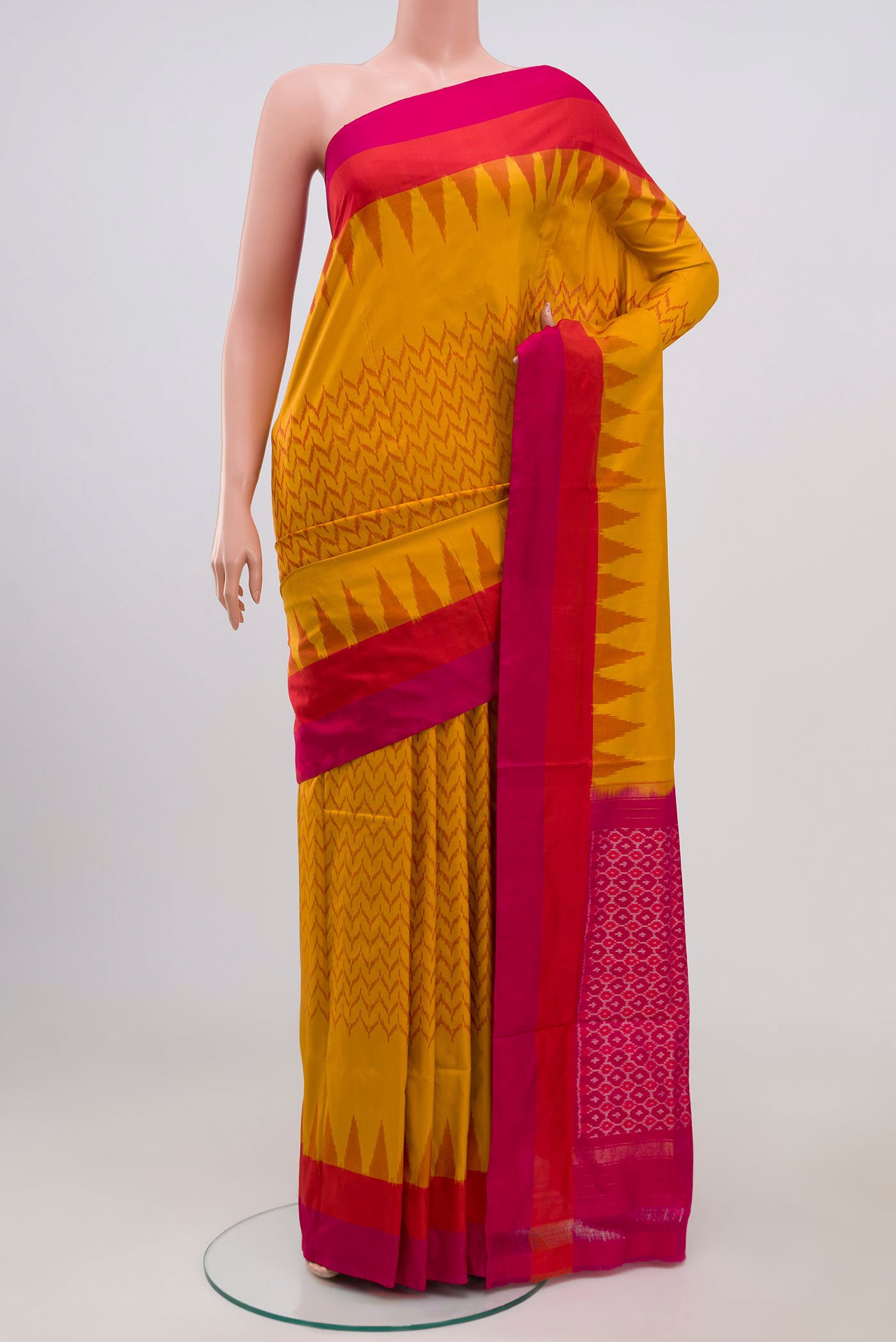 Mustard Pochampally Silk Saree with Ikat Print on the body and Plain Border.  displayed on a mannequin