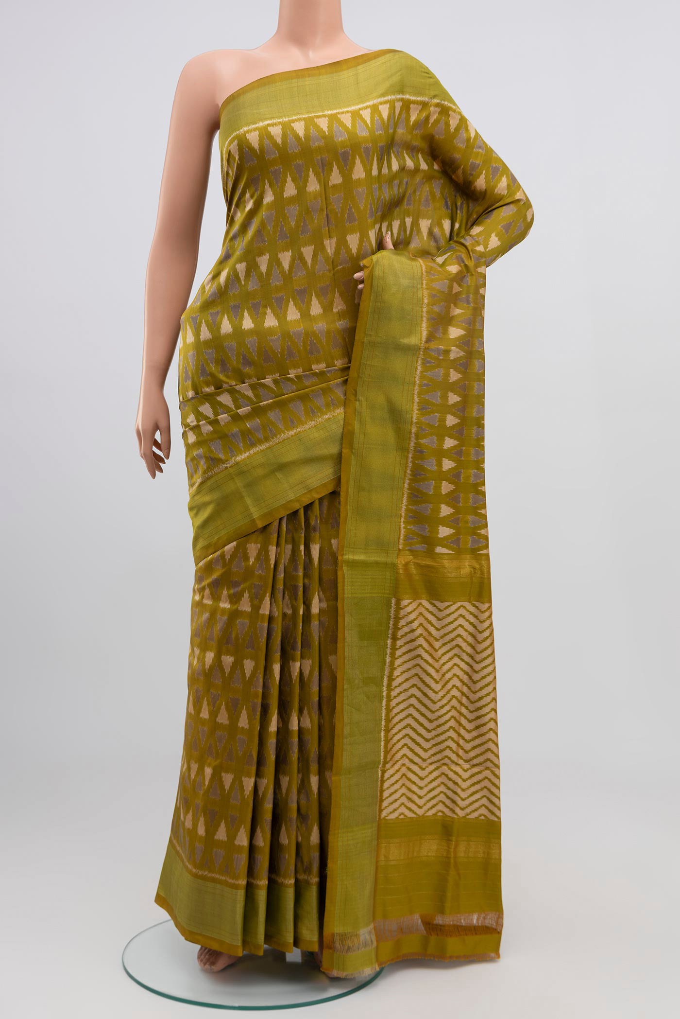 Green Pochampally Silk Saree with Ikat Print on the body and Zari Border.  displayed on a mannequin