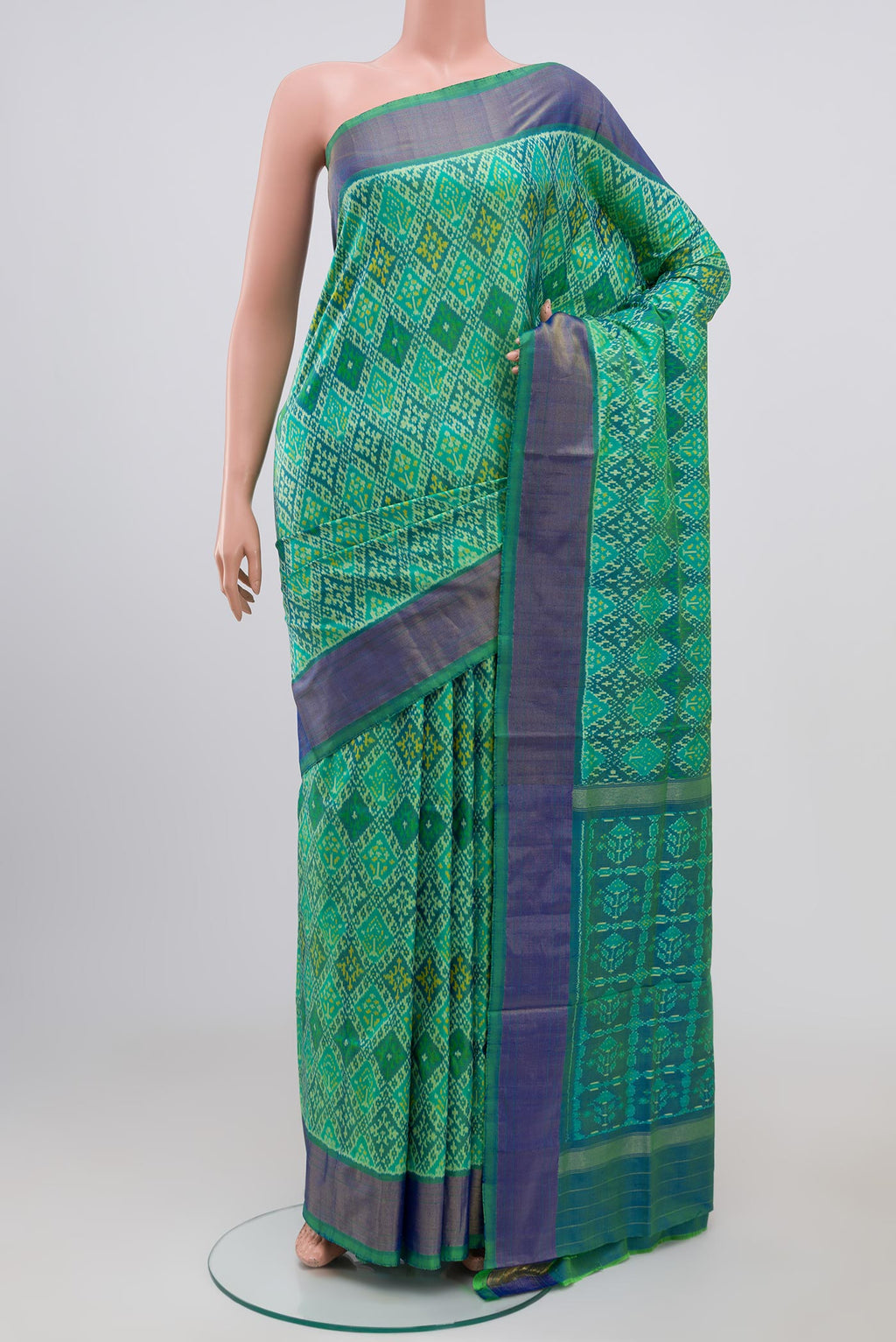 Light Green Pochampally Silk Saree with Ikat Print on the body and Zari Border.  displayed on a mannequin