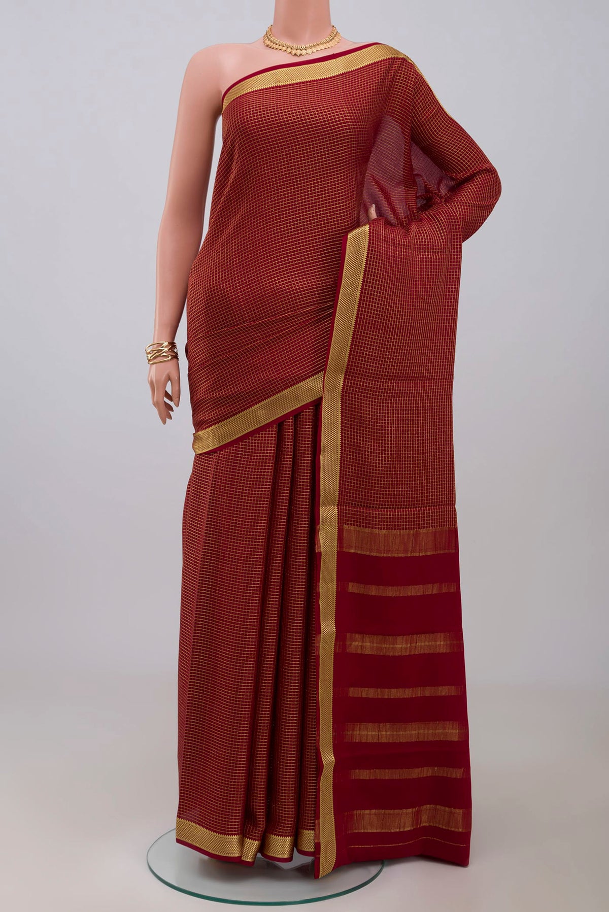 Maroon Crepe Saree with Checked design on the body and Zari Border.  displayed on a mannequin