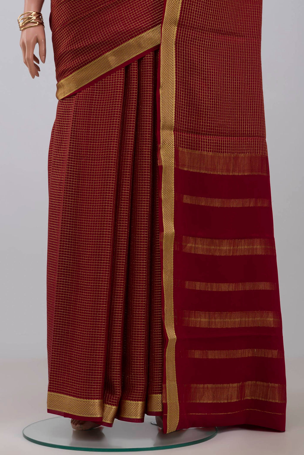 Pleats and pallu of Maroon Crepe Saree with Checked design on the body and Zari Border. 