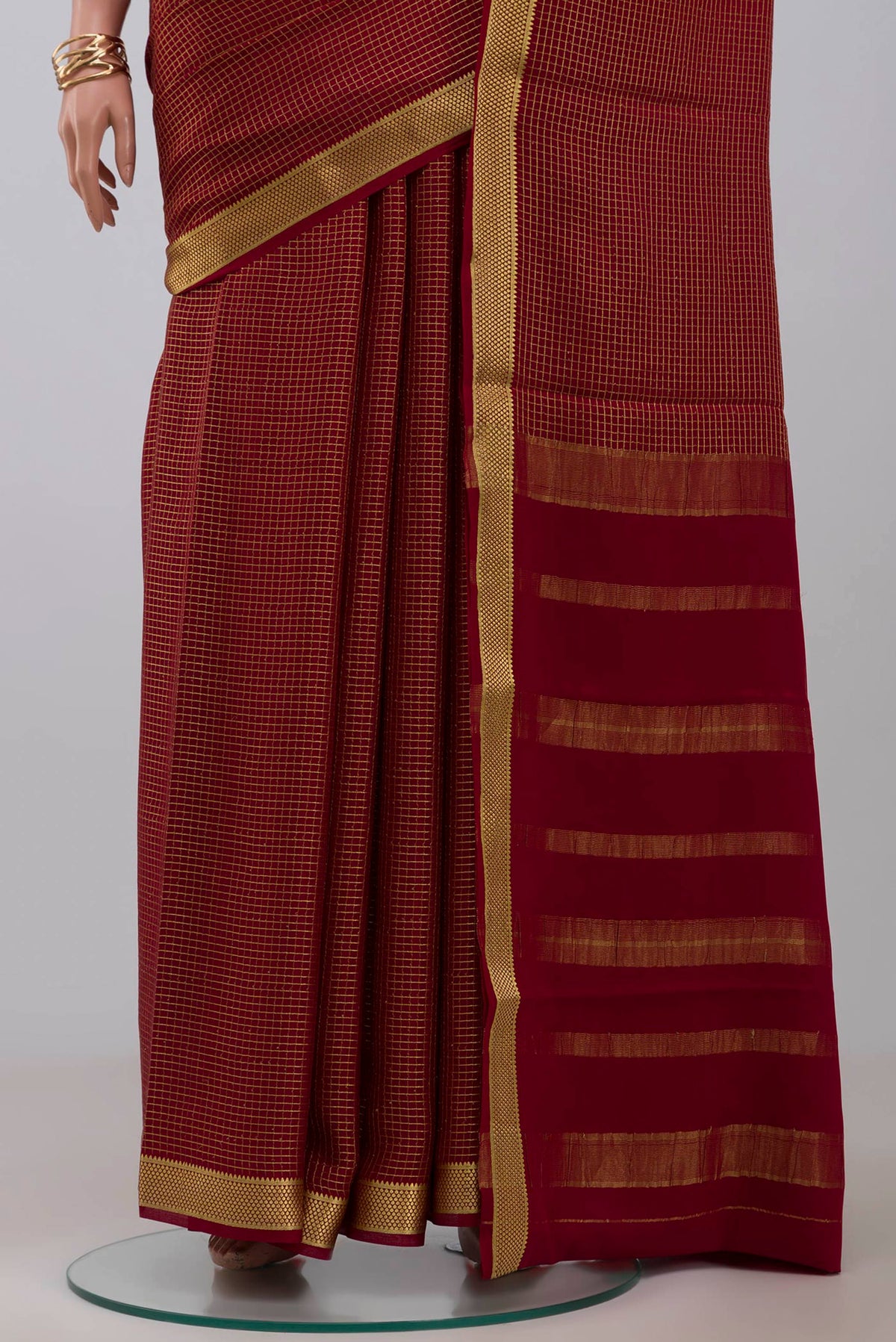 Pleats and pallu of Maroon Crepe Saree with Checked design on the body and Zari Border. 