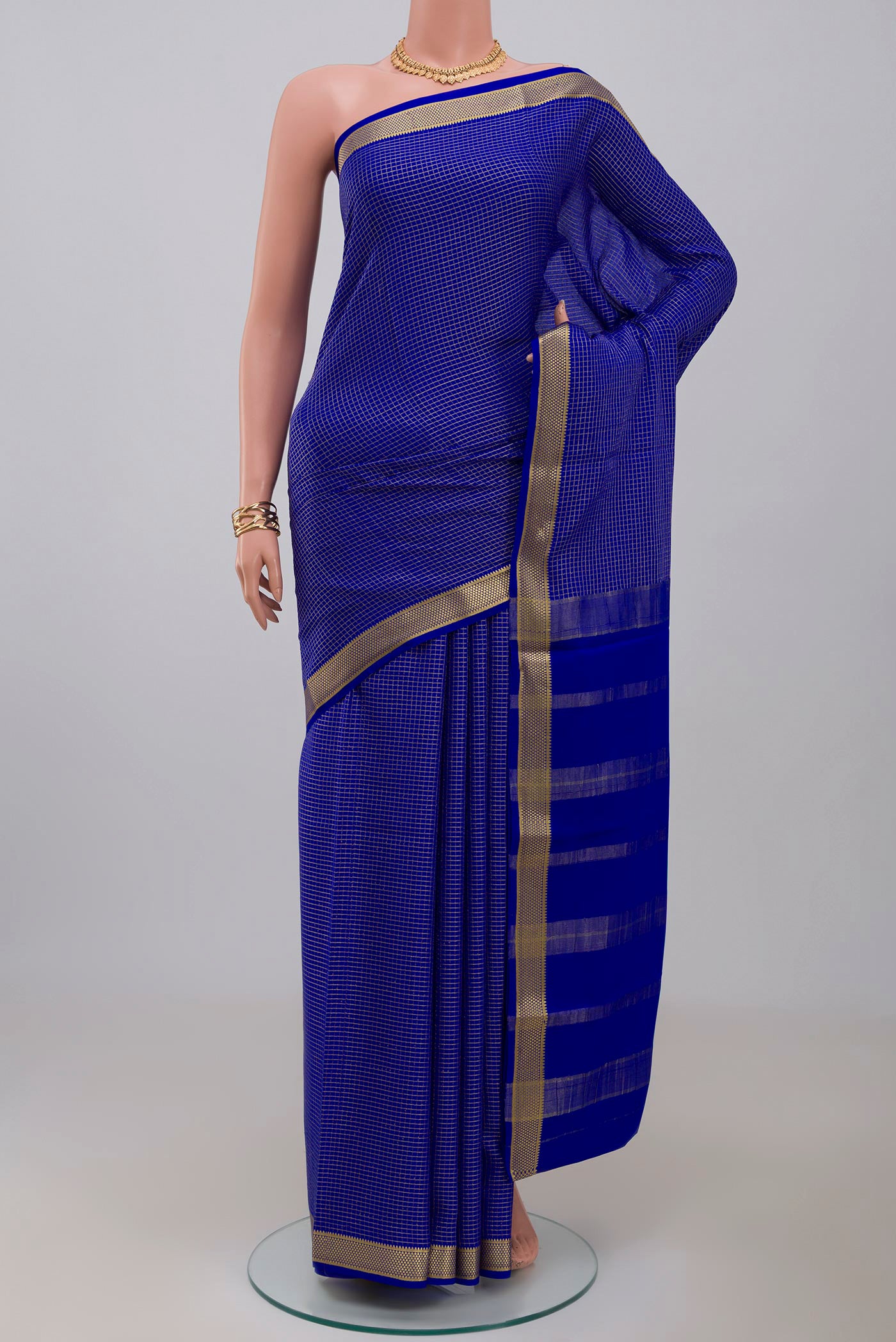 Blue Crepe Saree with Checked design on the body and Zari Border.  displayed on a mannequin