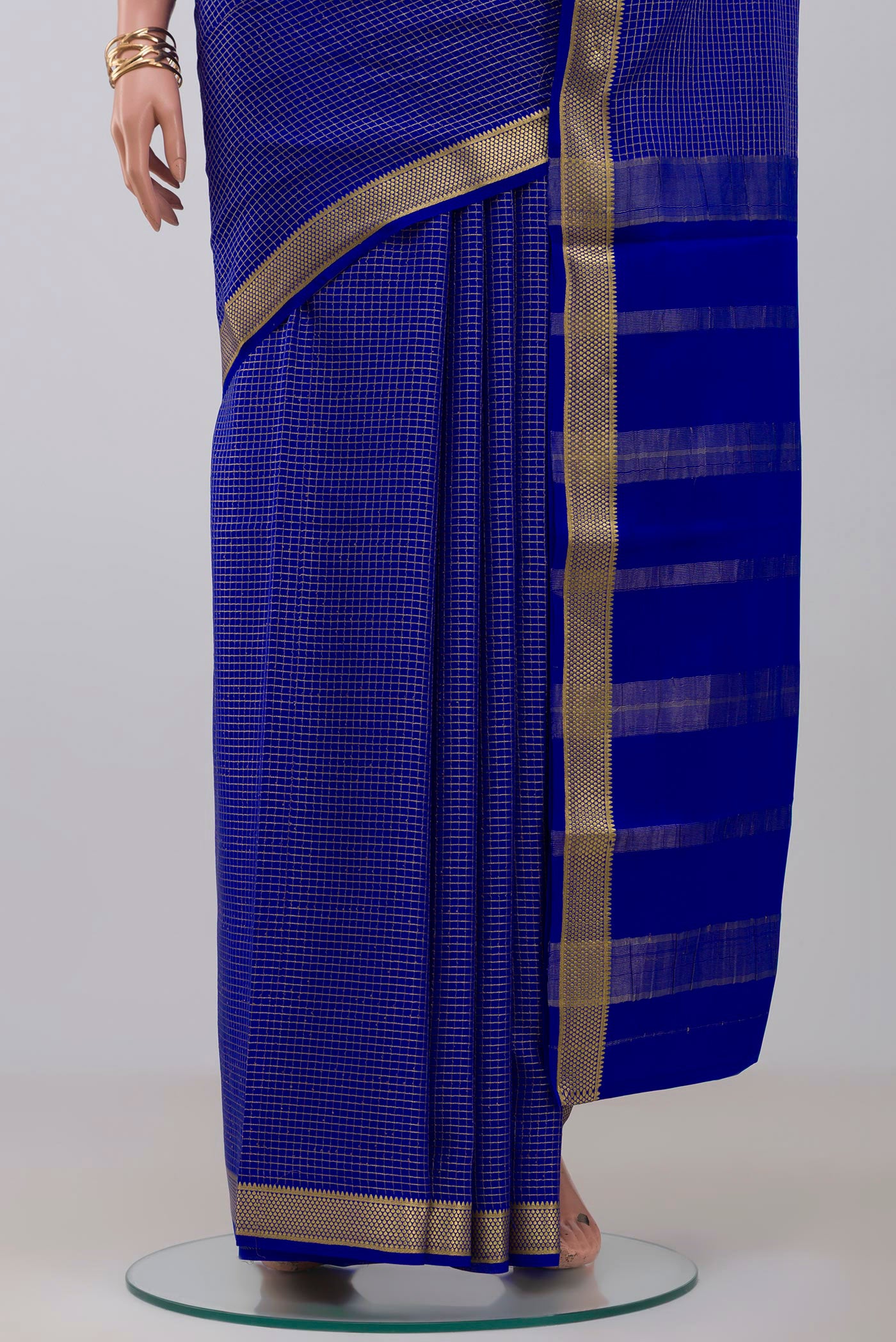 Pleats and pallu of Blue Crepe Saree with Checked design on the body and Zari Border. 