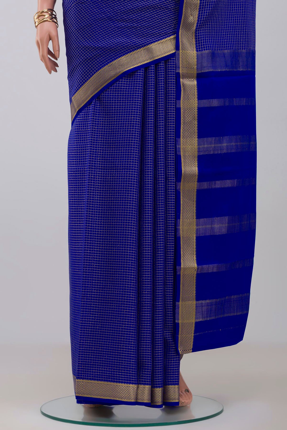 Pleats and pallu of Blue Crepe Saree with Checked design on the body and Zari Border. 