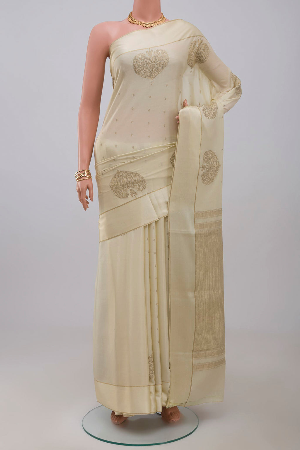 Cream Crepe Saree with Zari Butta on the body and Thin Zari Line.  displayed on a mannequin