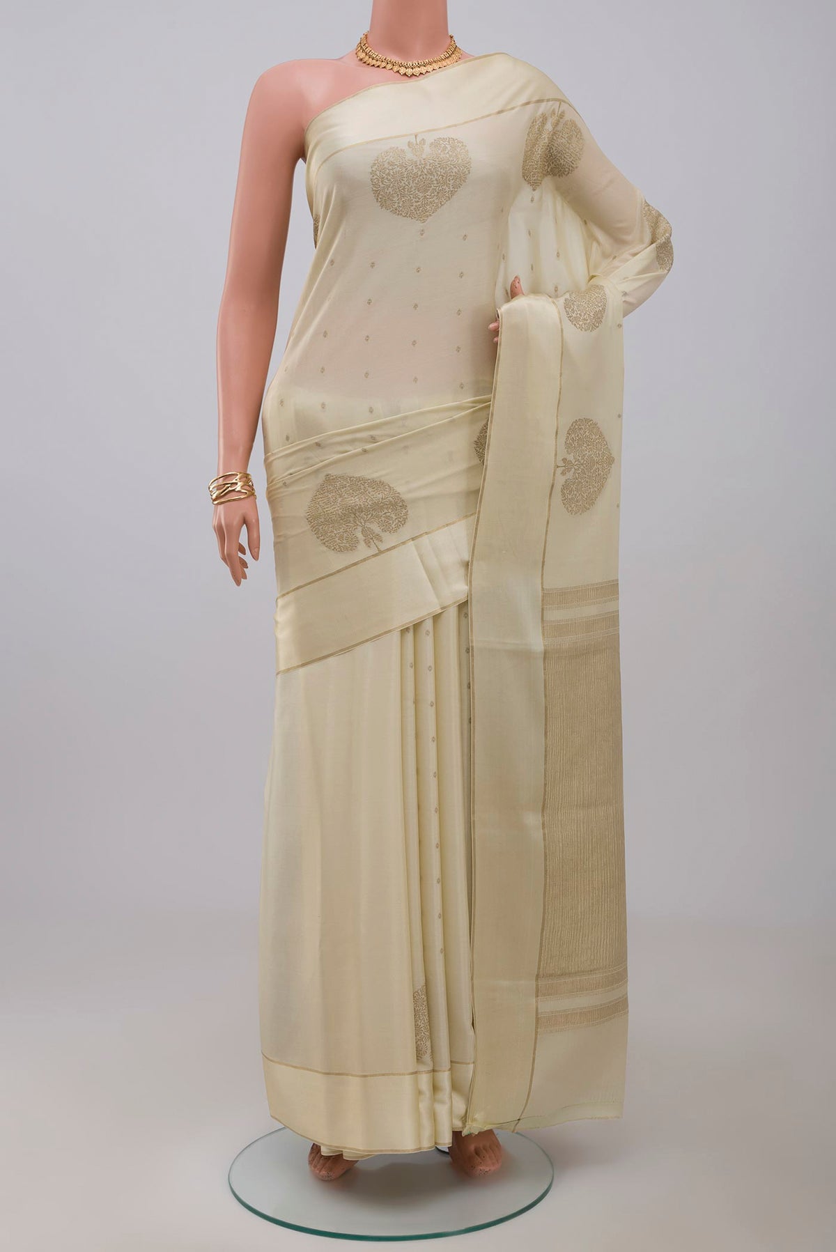 Cream Crepe Saree with Zari Butta on the body and Thin Zari Line.  displayed on a mannequin