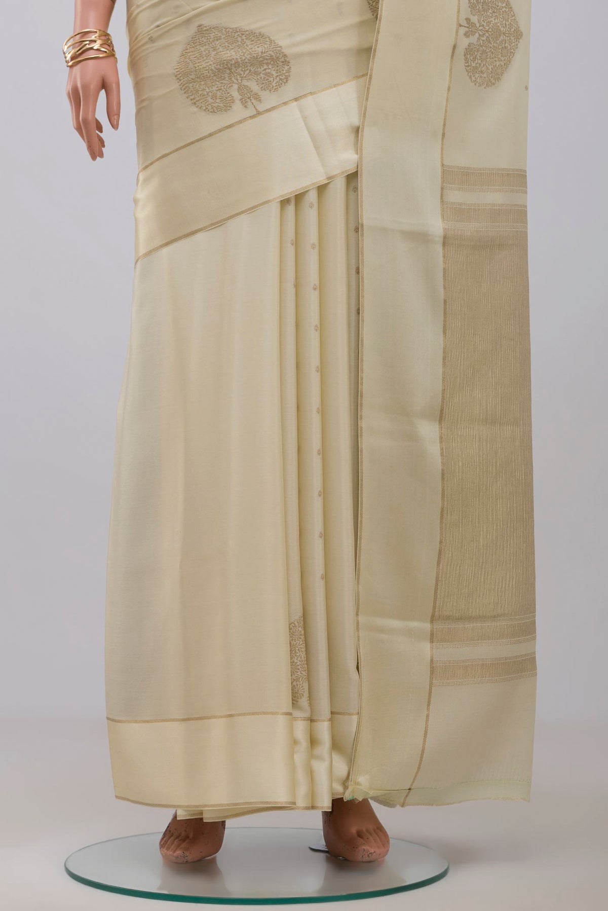 Pleats and pallu of Cream Crepe Saree with Zari Butta on the body and Thin Zari Line. 