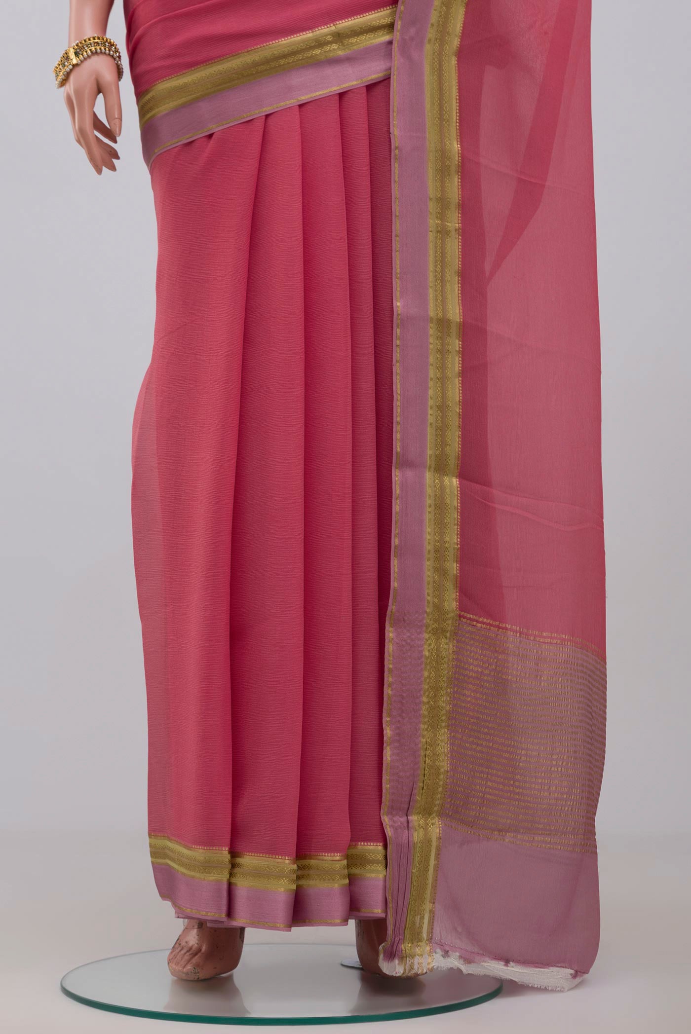 Pleats and pallu of Peach Chiffon Saree with Plain Body and Zari Border. 
