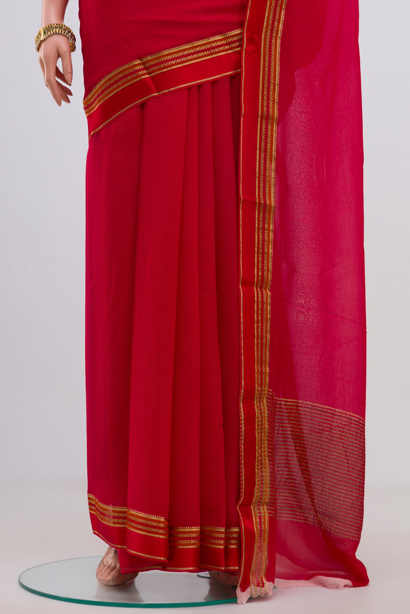 Pleats and pallu of Red Chiffon Saree with Plain Body and Zari Border. 