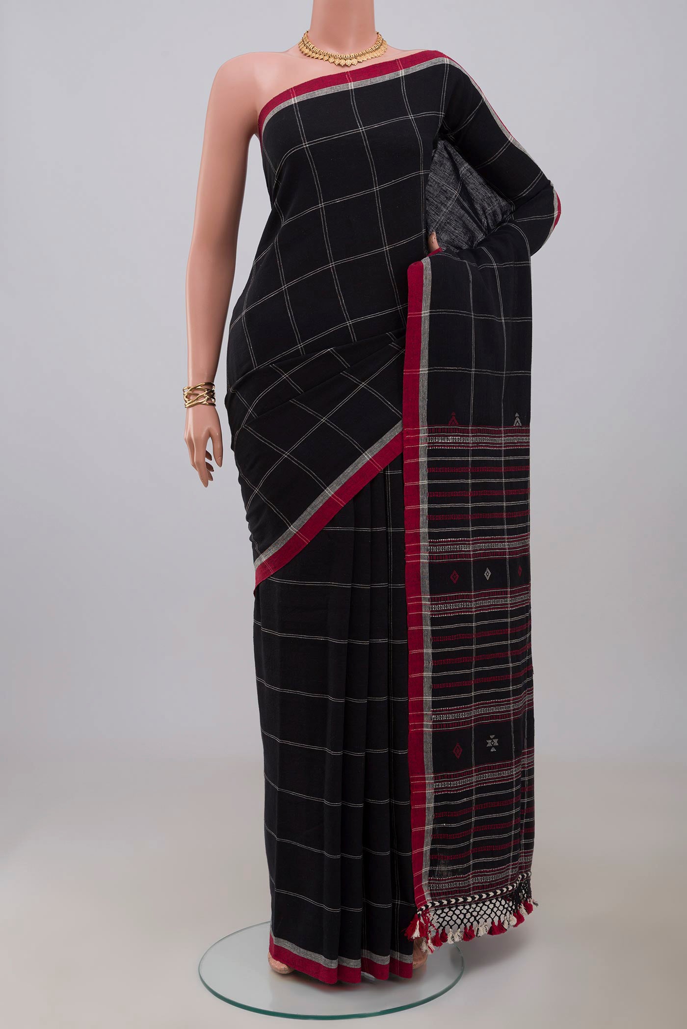 Black Assam Cotton Saree with Checked design on the body and Thread Border.  displayed on a mannequin