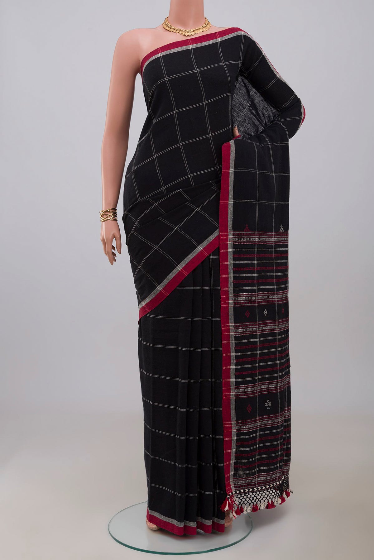 Black Assam Cotton Saree with Checked design on the body and Thread Border.  displayed on a mannequin