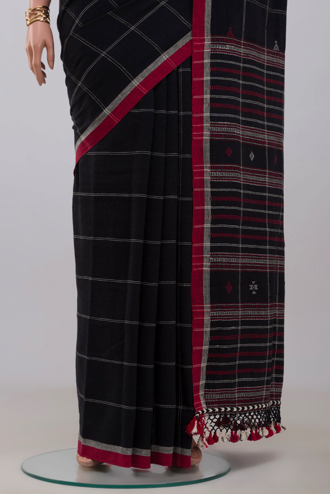 Pleats and pallu of Black Assam Cotton Saree with Checked design on the body and Thread Border. 