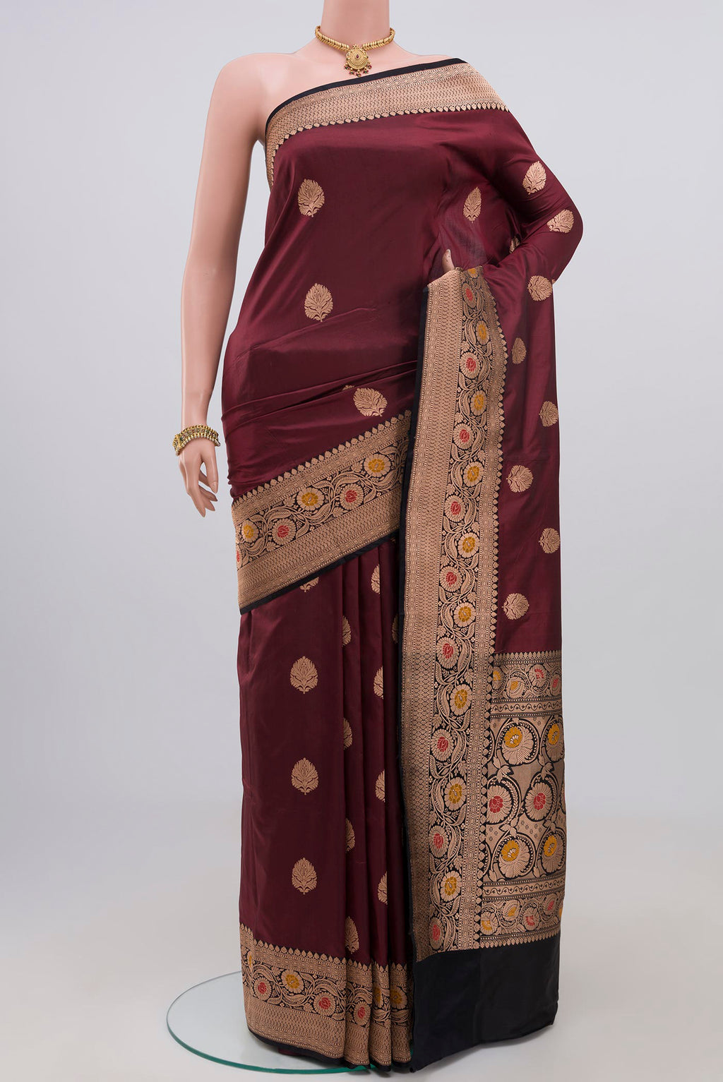 Maroon Banarasi Katan Silk Saree with Zari Butta on the body and Zari Border.  displayed on a mannequin