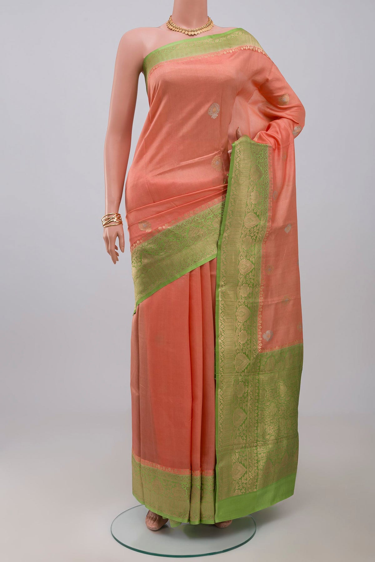Peach Banarasi Katan Silk Saree with Zari Butta on the body and Fancy Border.  displayed on a mannequin