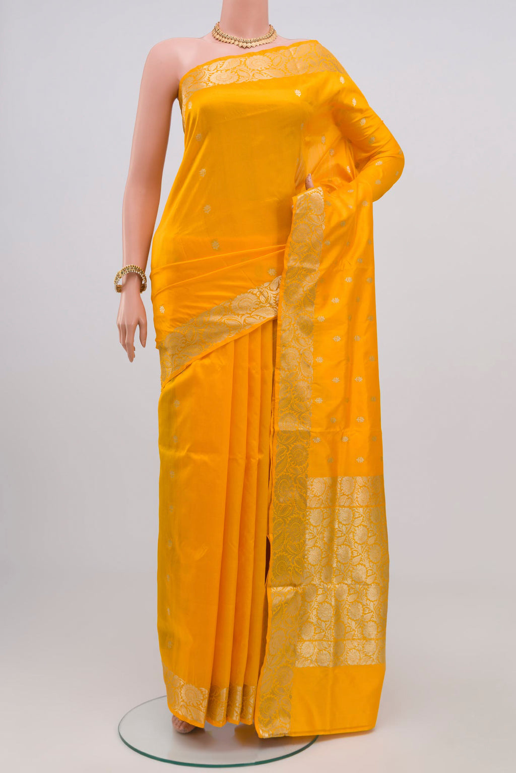 Yellow Banarasi Katan Silk Saree with Zari Butta on the body and Zari Border.  displayed on a mannequin