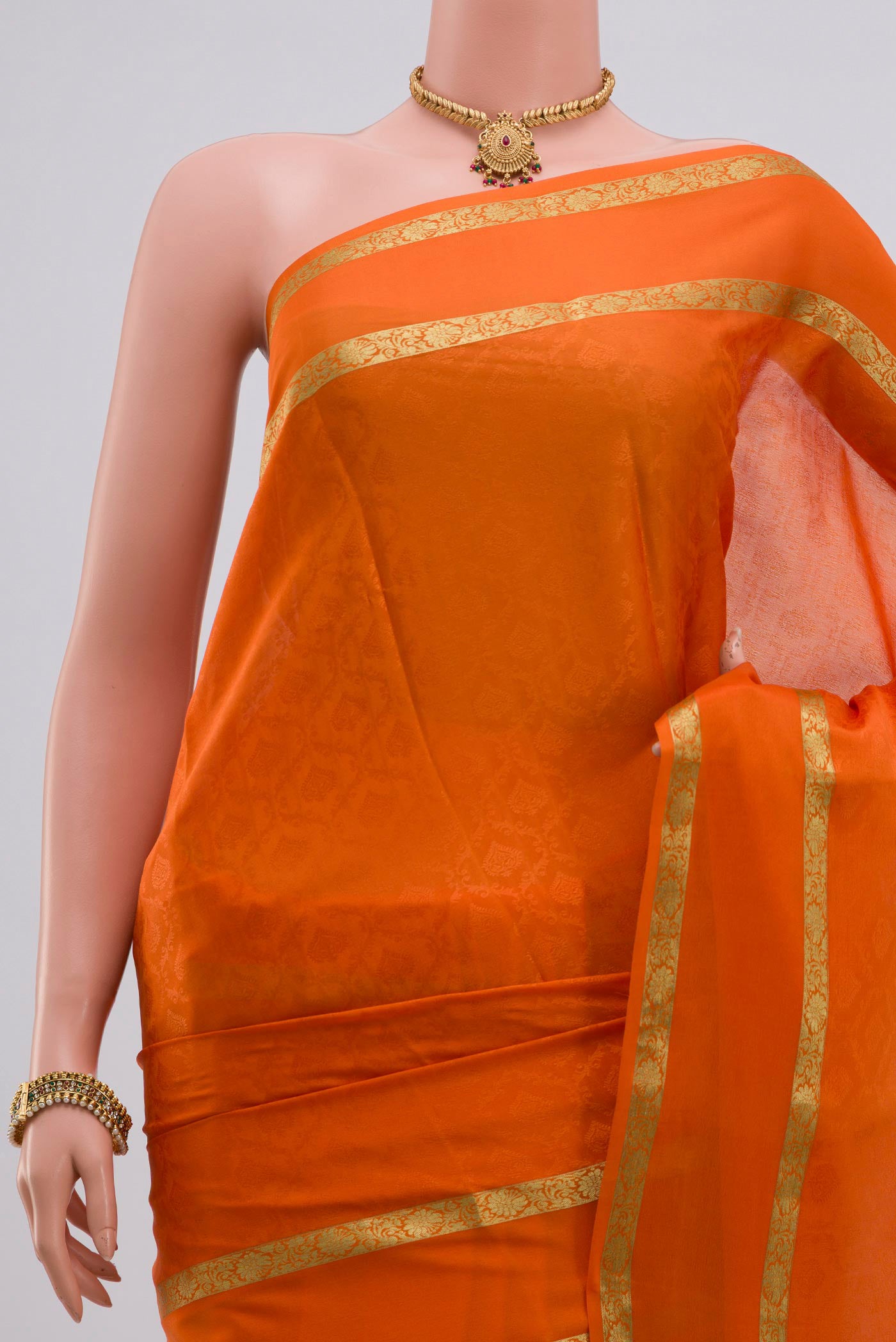 Border image of Orange Crepe Saree with Jacquard design on the body and Zari Border. 