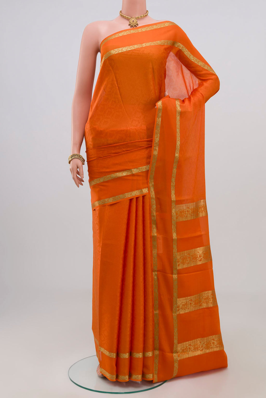 Orange Crepe Saree with Jacquard design on the body and Zari Border.  displayed on a mannequin