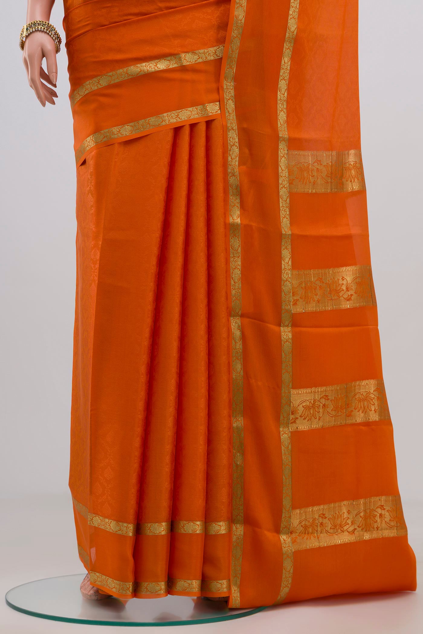 Pleats and pallu of Orange Crepe Saree with Jacquard design on the body and Zari Border. 