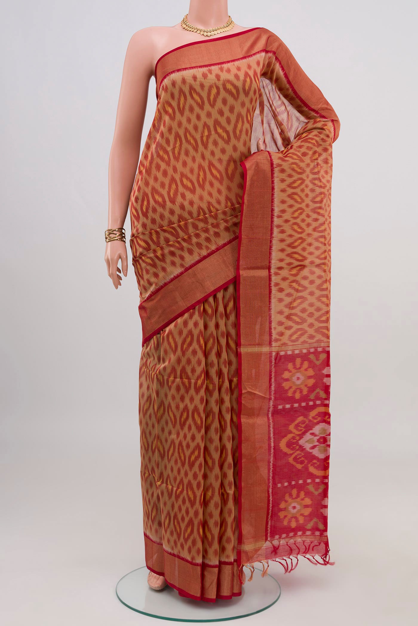 Beige Silk Cotton Saree with Ikat design on the body and Zari Border.  displayed on a mannequin