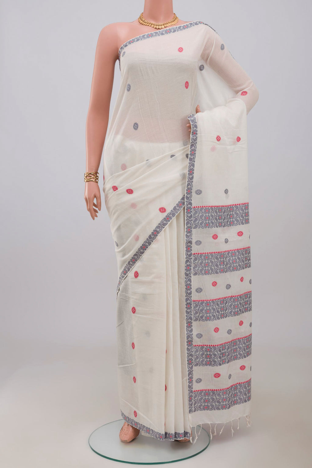 White Assam Cotton Saree with Thread Butta on the body and Thread Border.  displayed on a mannequin