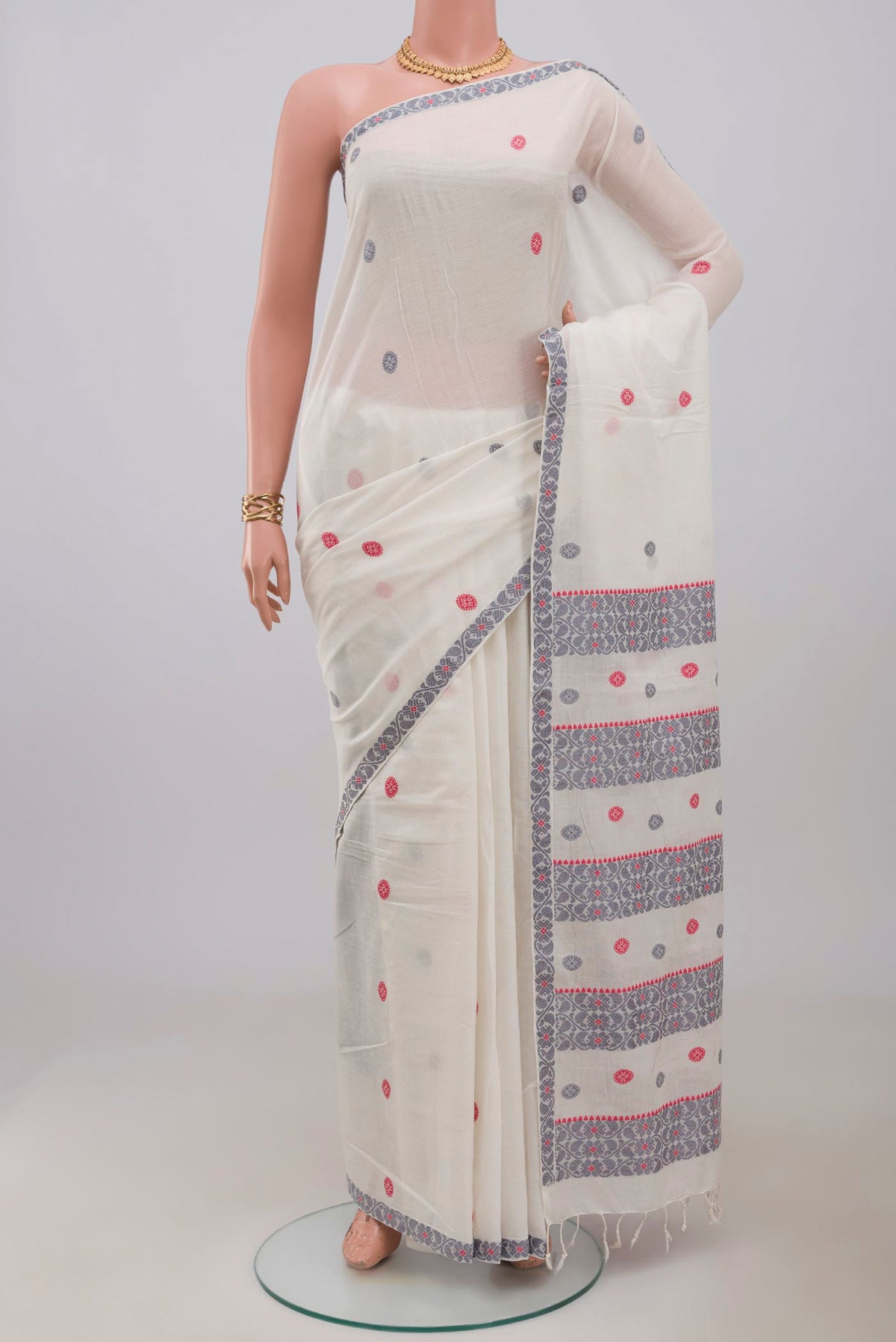 White Assam Cotton Saree with Thread Butta on the body and Thread Border.  displayed on a mannequin
