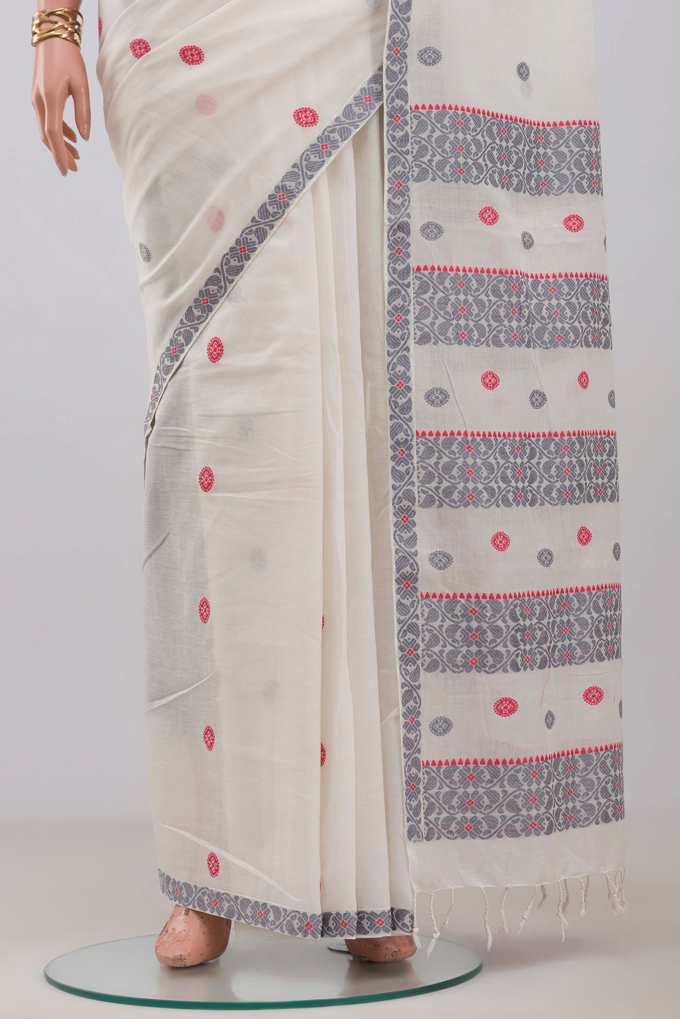 Pleats and pallu of White Assam Cotton Saree with Thread Butta on the body and Thread Border. 