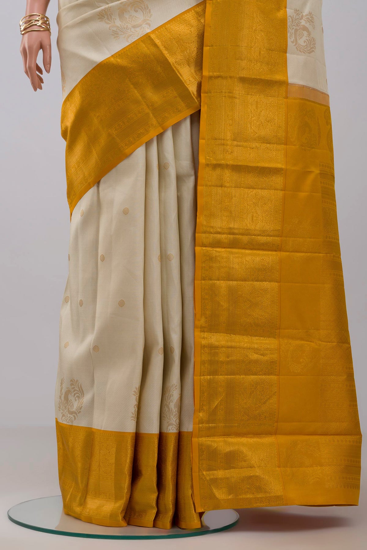 Pleats and pallu of Cream Kanjivaram Saree with Zari Butta on the body and Zari Border. 