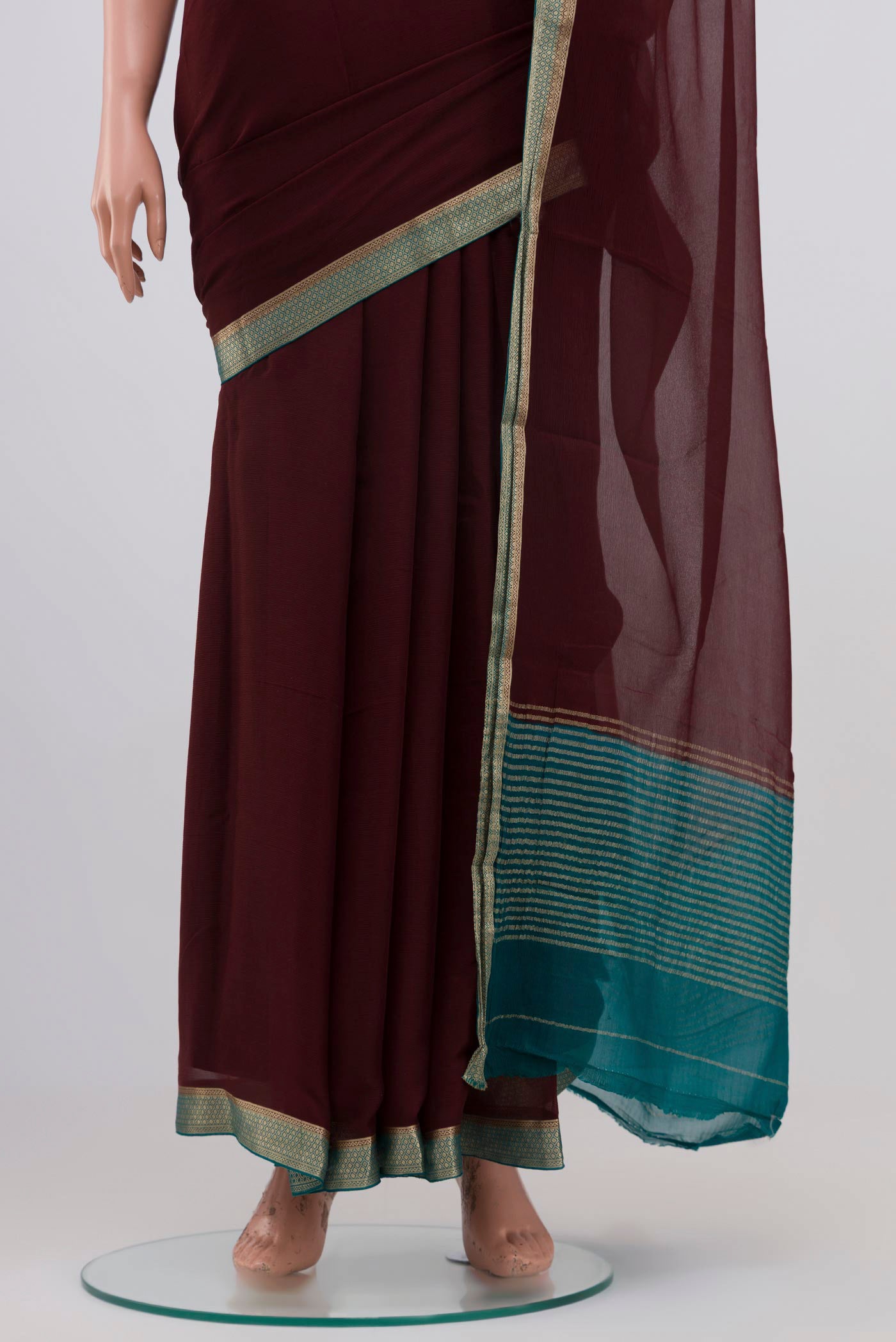 Pleats and pallu of Brown Chiffon Saree with Plain Body and Zari Border. 
