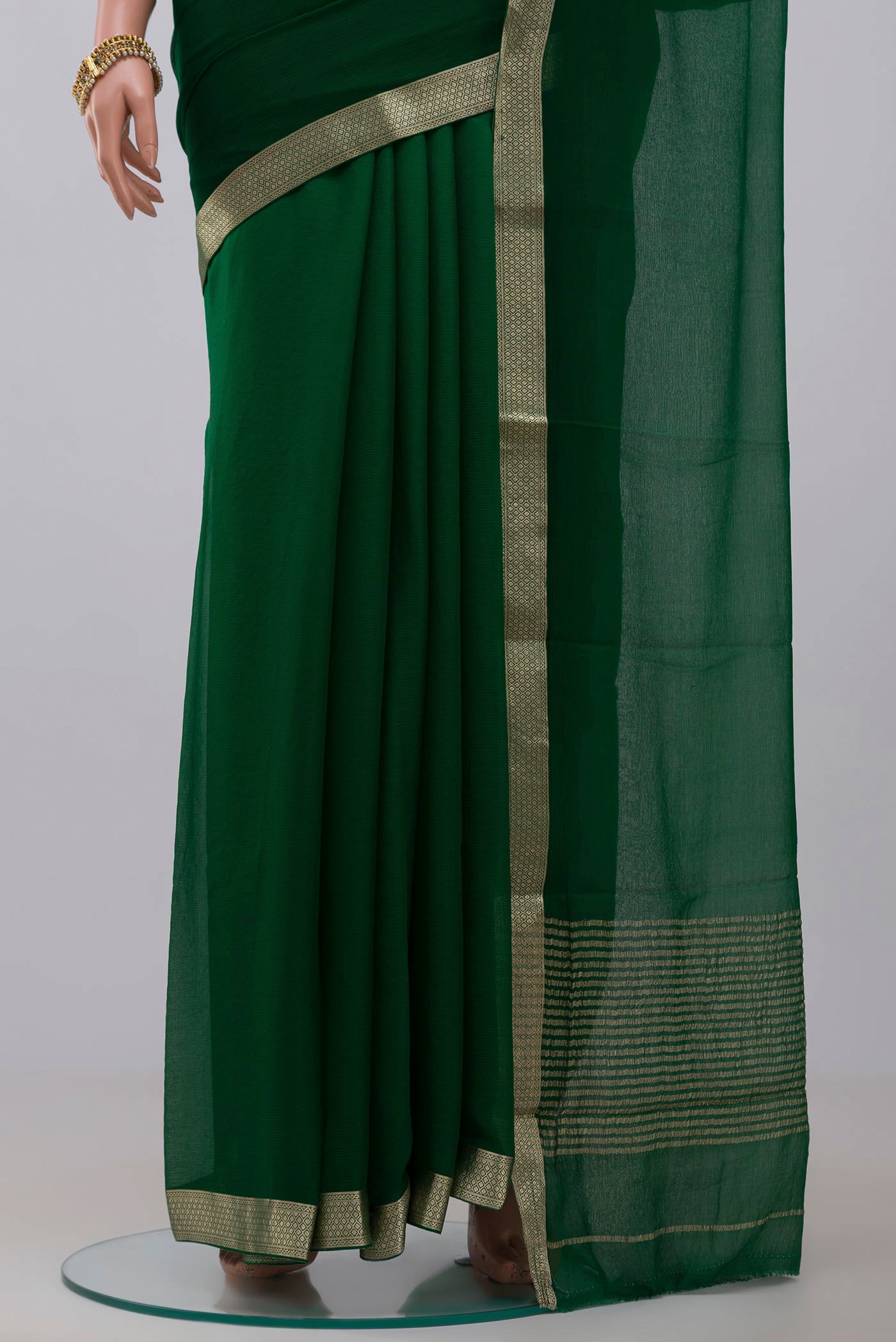 Pleats and pallu of Green Chiffon Saree with Plain Body and Zari Border. 