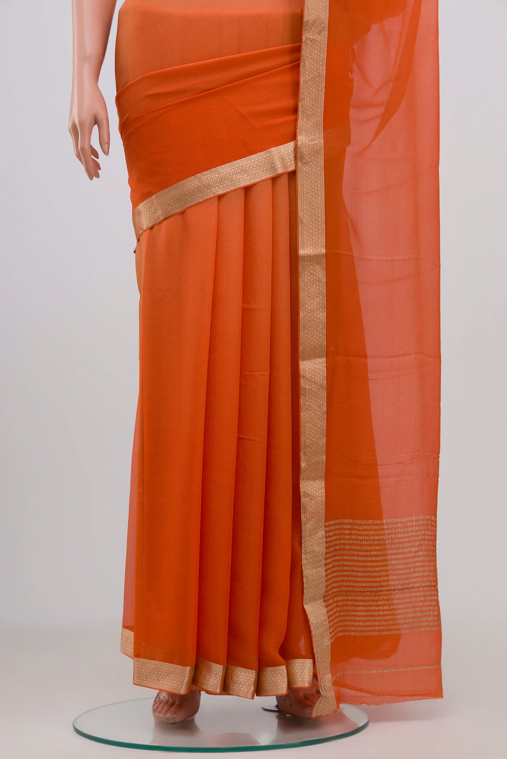 Pleats and pallu of Orange Chiffon Saree with Plain Body and Zari Border. 