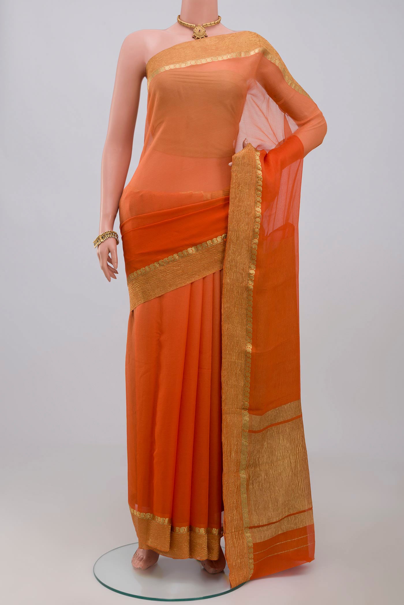 Orange Chiffon Saree with Plain Body and Zari Border.  displayed on a mannequin