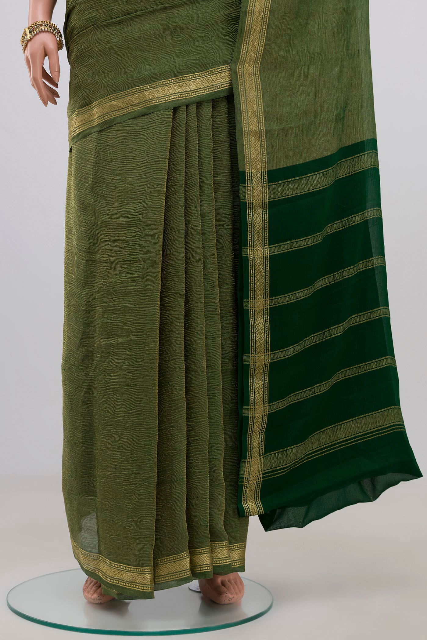 Pleats and pallu of Green Chiffon Saree with Plain Body and Zari Border. 