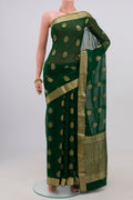 Green Georgette Saree with Fancy on the body and Zari Border.  displayed on a mannequin