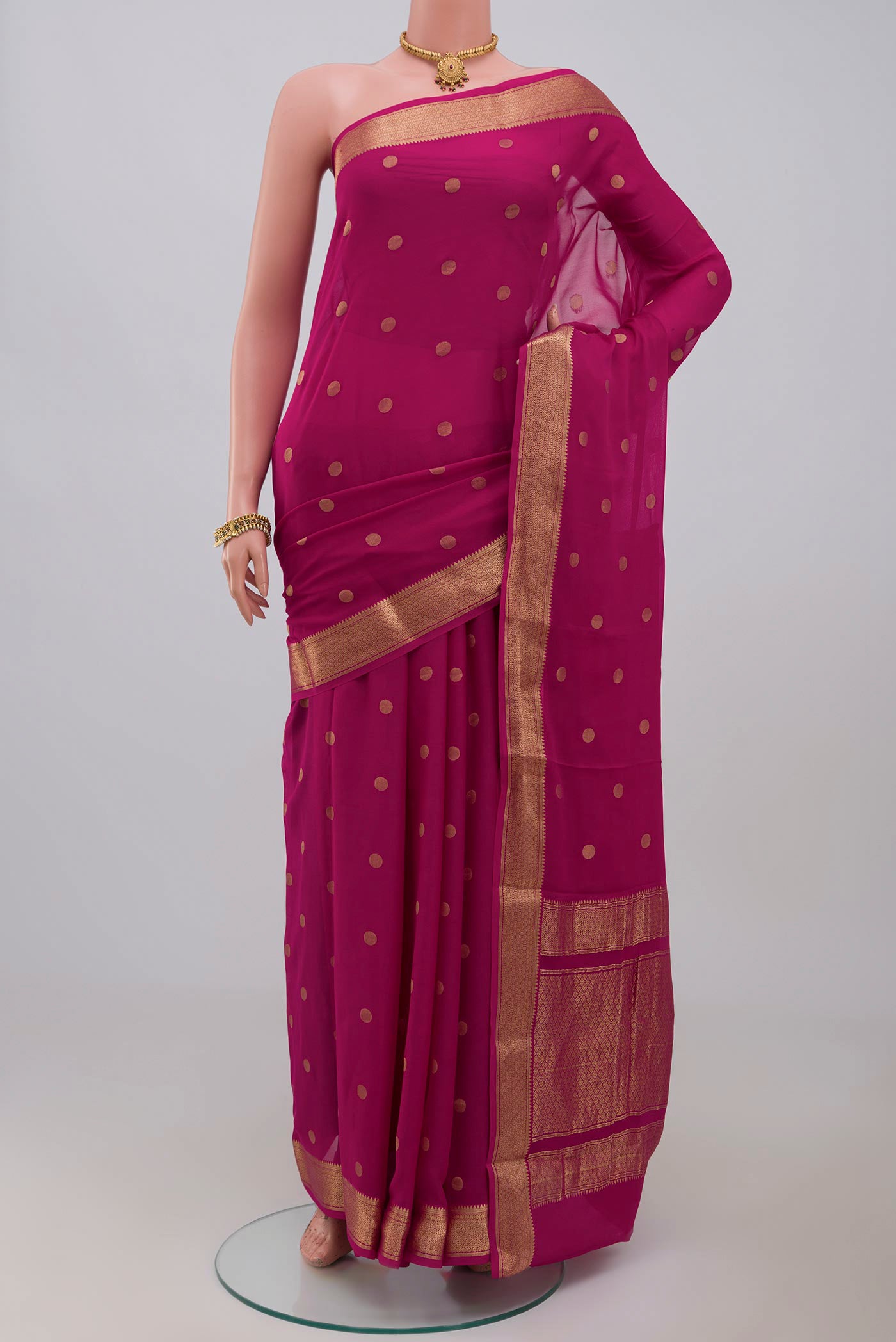 Pink Georgette Saree with Zari Butta on the body and Zari Border.  displayed on a mannequin