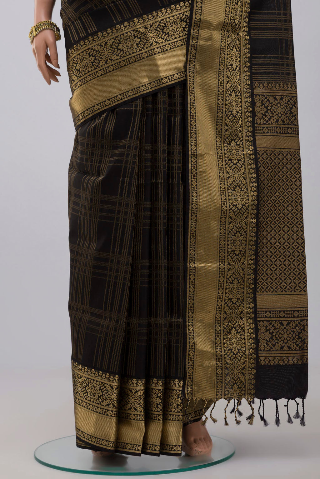 Pleats and pallu of Black Soft Silk Saree with Checked design on the body and Zari Border. 