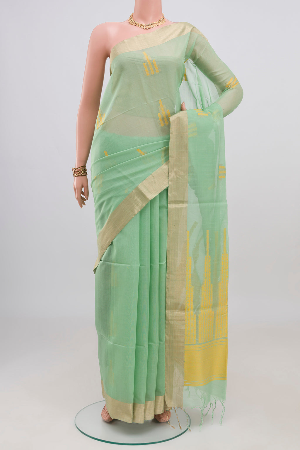 Pista Green Silk Cotton Saree with Zari And Thread Butta on the body and Zari Border.  displayed on a mannequin