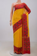 Yellow Rajkot Patola Silk Saree with Ikat design on the body and Ikat Border.  displayed on a mannequin